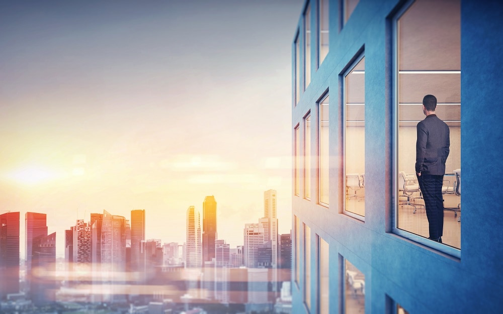 man in skyscraper overlooking futuristic city